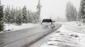 The back of a car driving through a wintry, snowy road